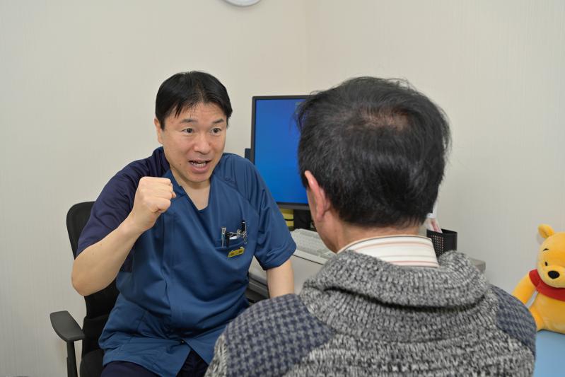 療法士が利用者に向き合うリハビリテーションの場面