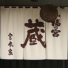 公式会社案内に掲載された、杉玉と蔵の暖簾が見える酒蔵入口