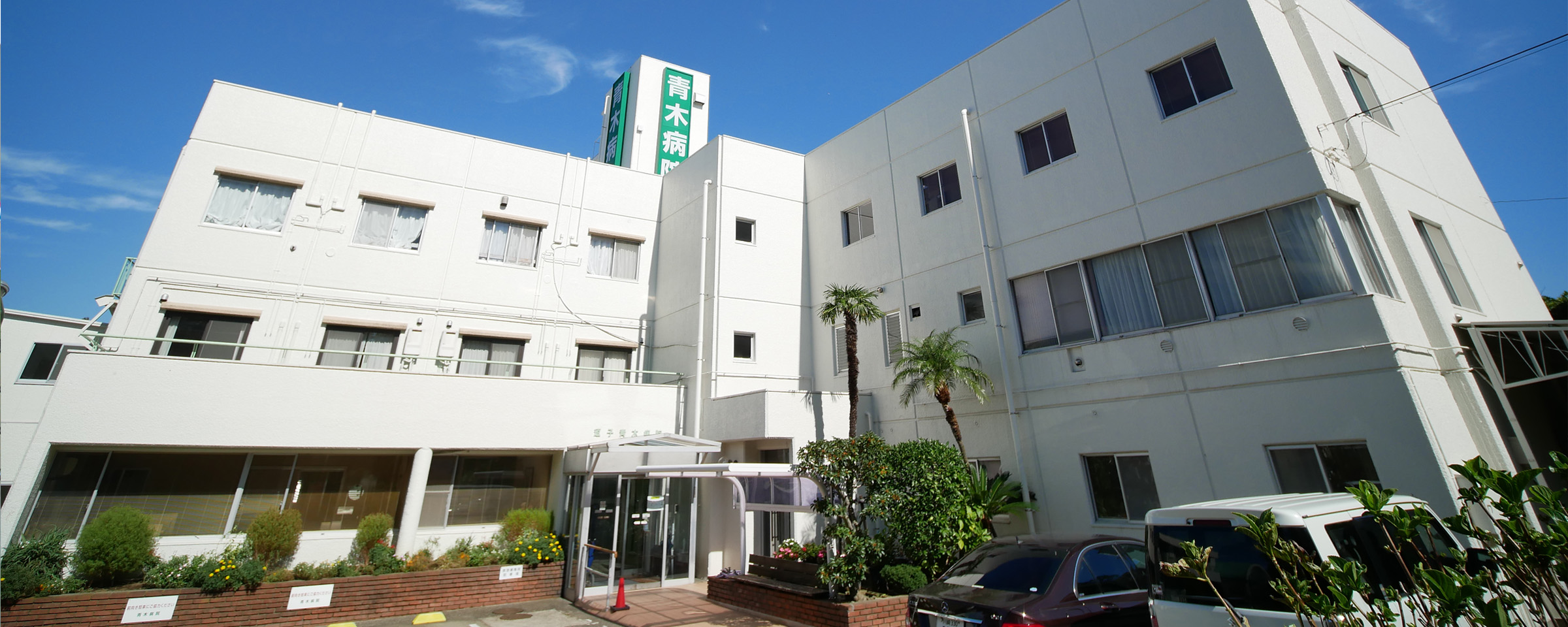 公式トップに掲載された、青木病院名が見える正面入口側の外観