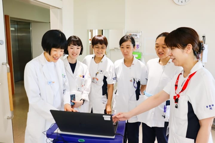 医療スタッフが端末を囲んで情報を確認する様子