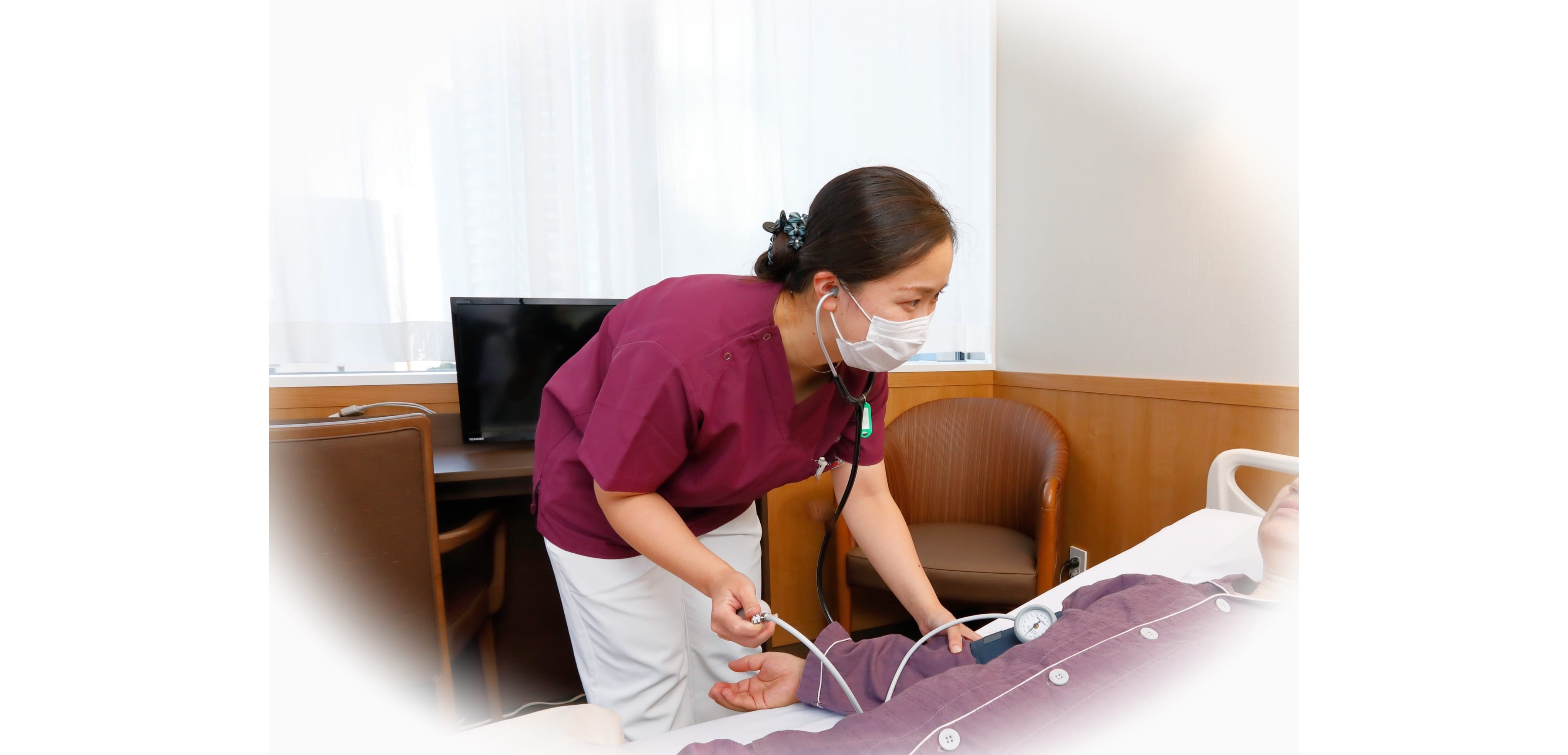 病室で患者をケアする看護師