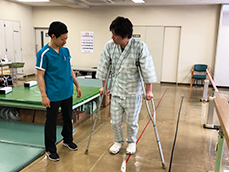 スタッフが歩行訓練を支援する様子