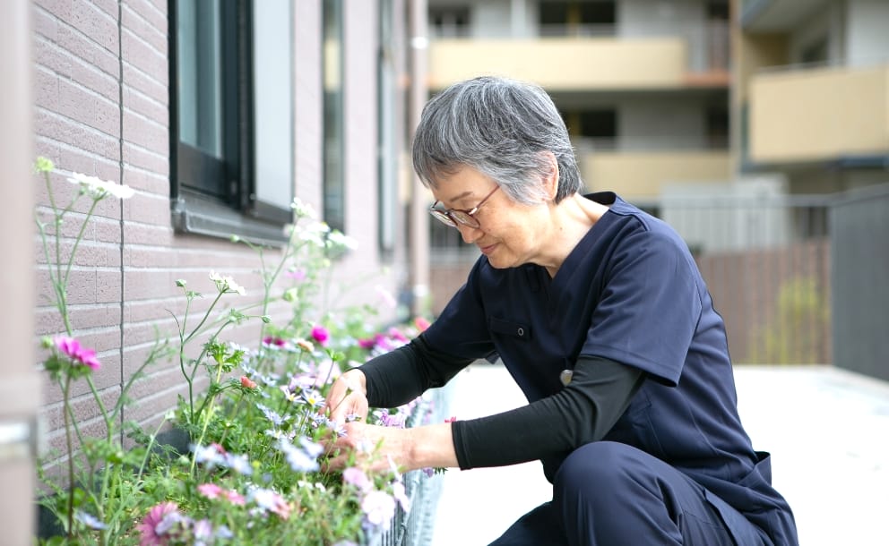 病院の庭園で花を手入れするスタッフ