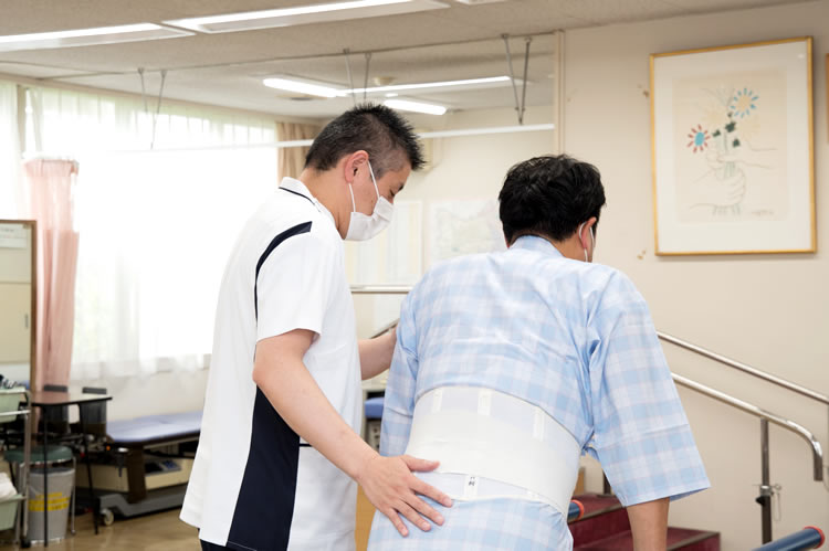 理学療法士が患者の立ち上がりを支援する様子
