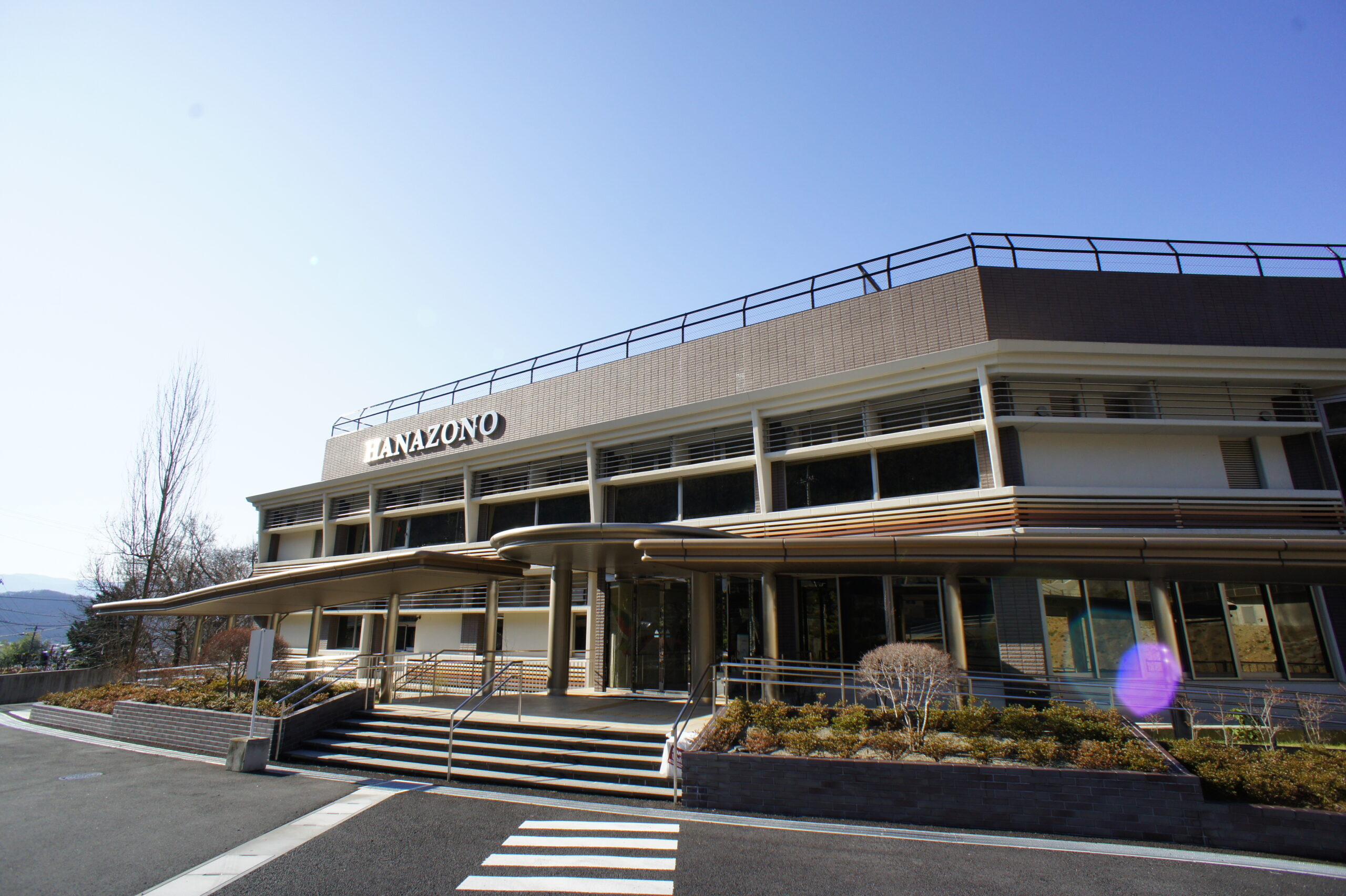 公式トップの施設写真。HANAZONOの名称表示がある正面外観