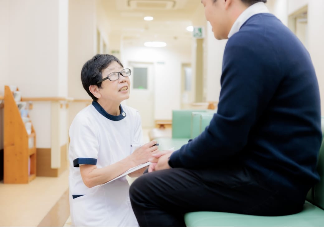 外来で患者を案内するスタッフ