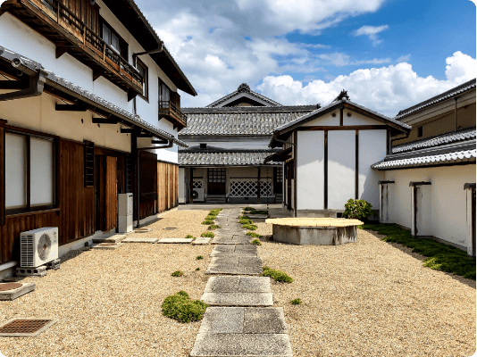 公式蔵元案内に掲載された、白壁と瓦屋根の酒蔵建物と中庭