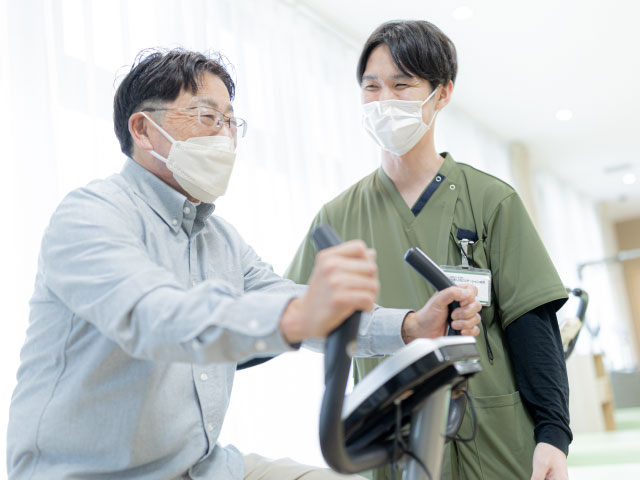 スタッフが支えるエアロバイク訓練