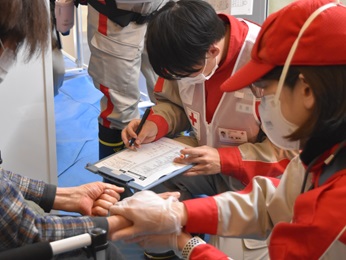 赤十字の救護班が救護所で診療を支援する様子