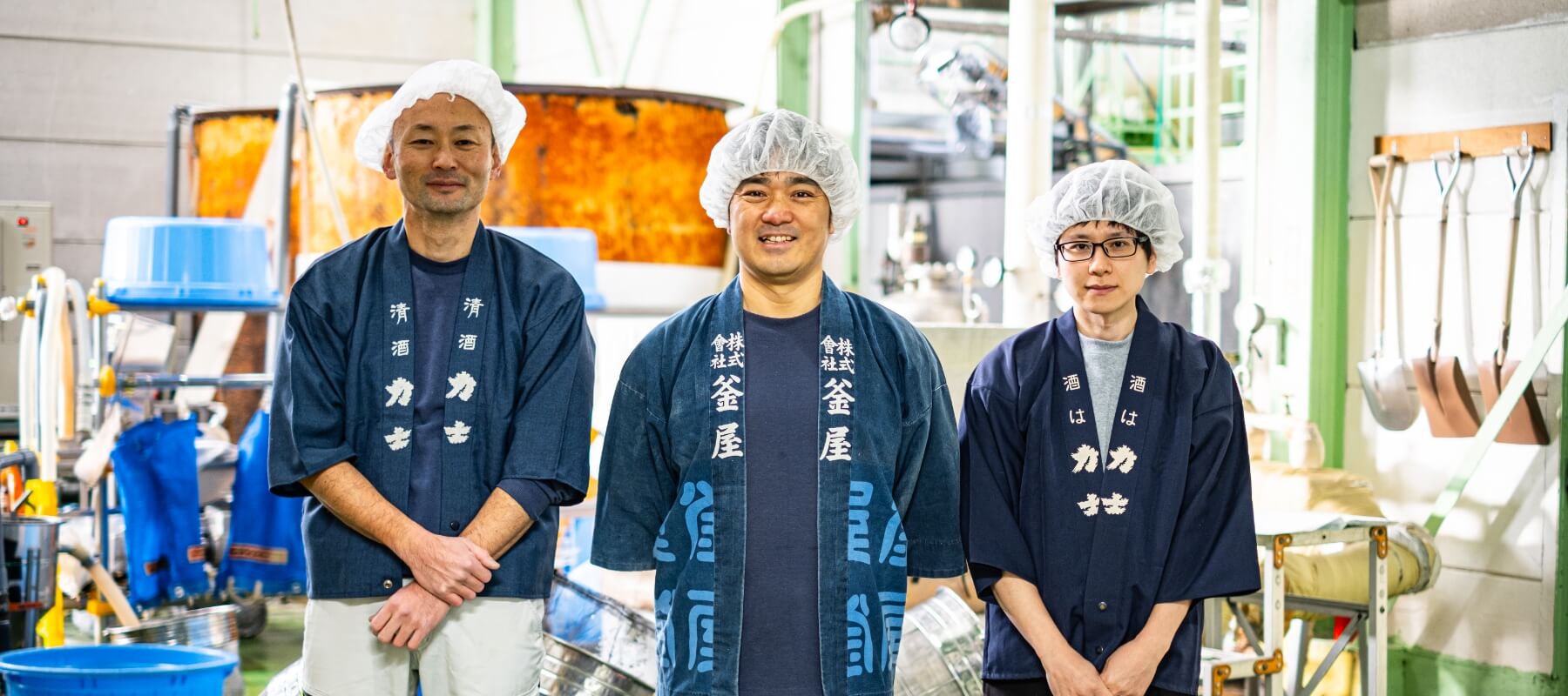 醸造設備の前に立つ釜屋の蔵人