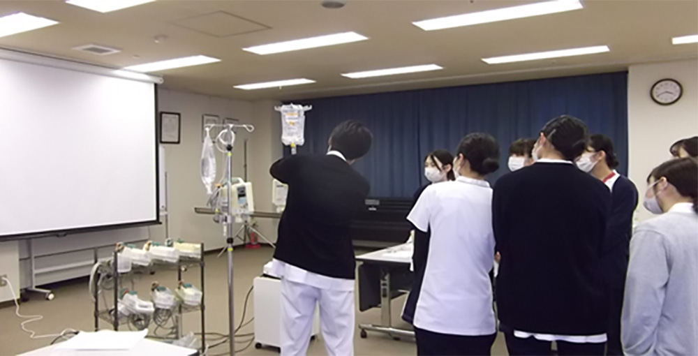 看護スタッフが医療機器を囲んで説明を受ける研修風景