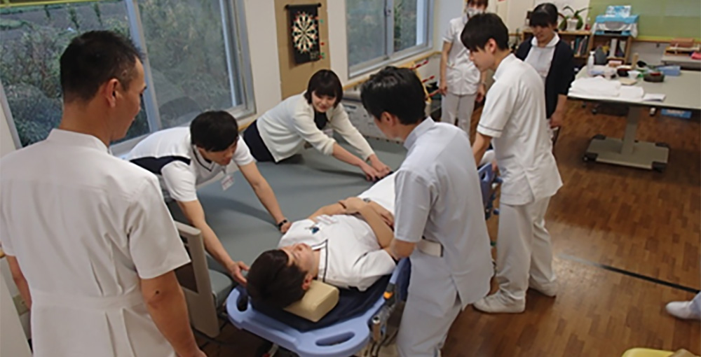 看護スタッフがベッドからストレッチャーへの移乗を練習する様子