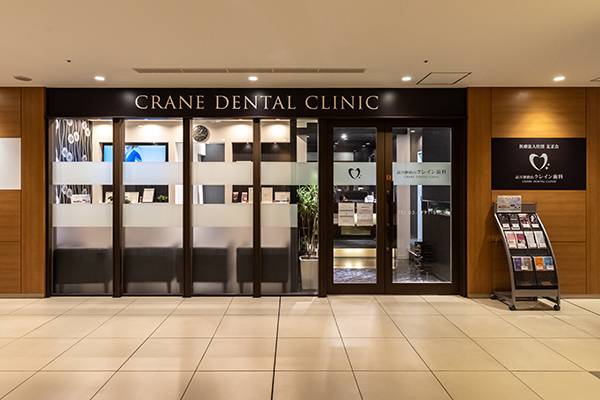 公式「院内のご紹介」に掲載される、CRANE DENTAL CLINICのサインが見える入口