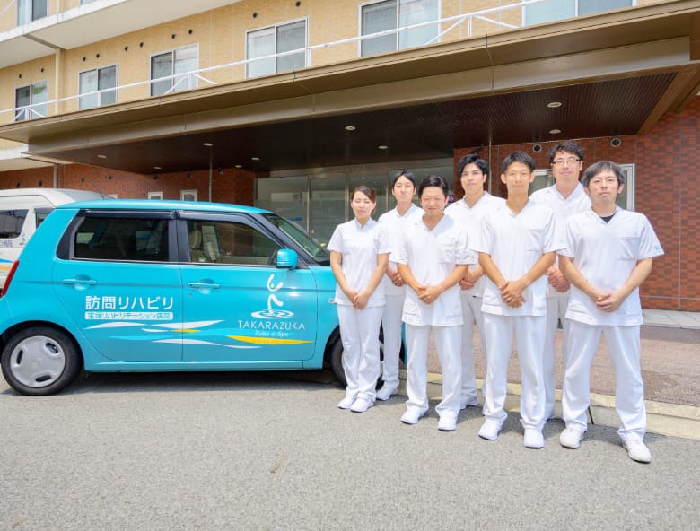 病院前の訪問リハビリテーション車両とスタッフ