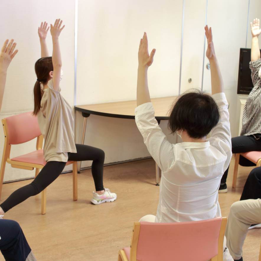 椅子に座って体操するデイケア活動