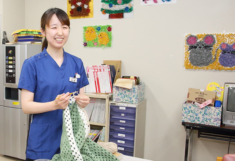 公式スタッフ紹介に掲載される作業活動の材料を手にする看護スタッフ