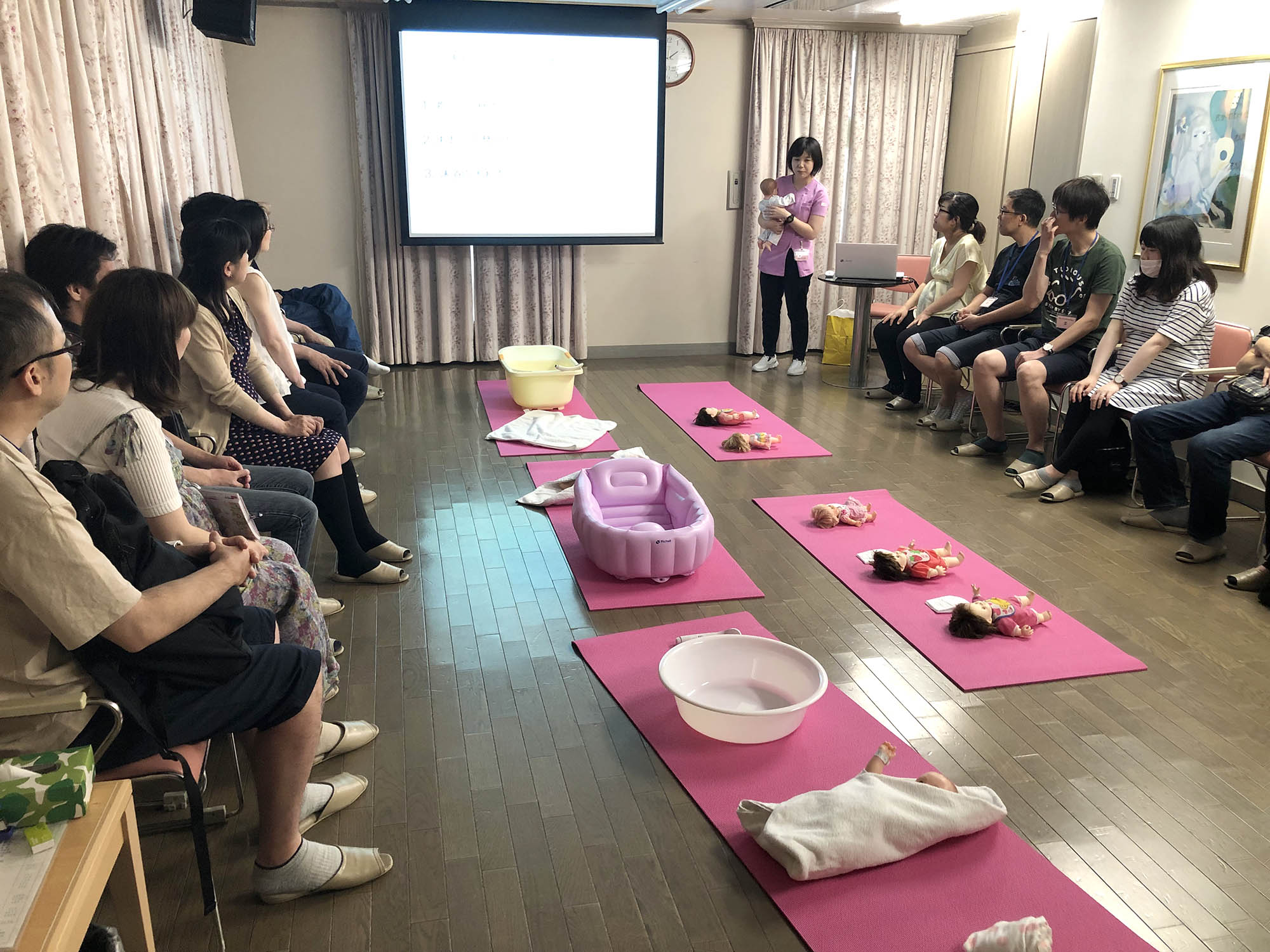 公式マタニティクラスページに掲載される、助産師が人形を使って説明する教室