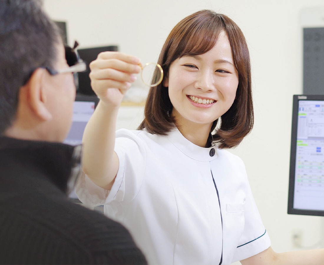 看護師が来院者に検査機器を示しながら説明する様子