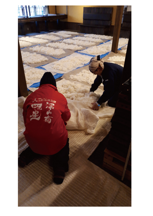 蔵人が麹を広げて手入れする様子