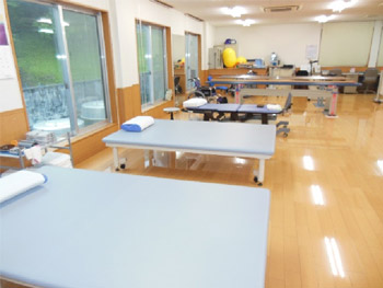 訓練台と器具を備えた無人のリハビリテーション室