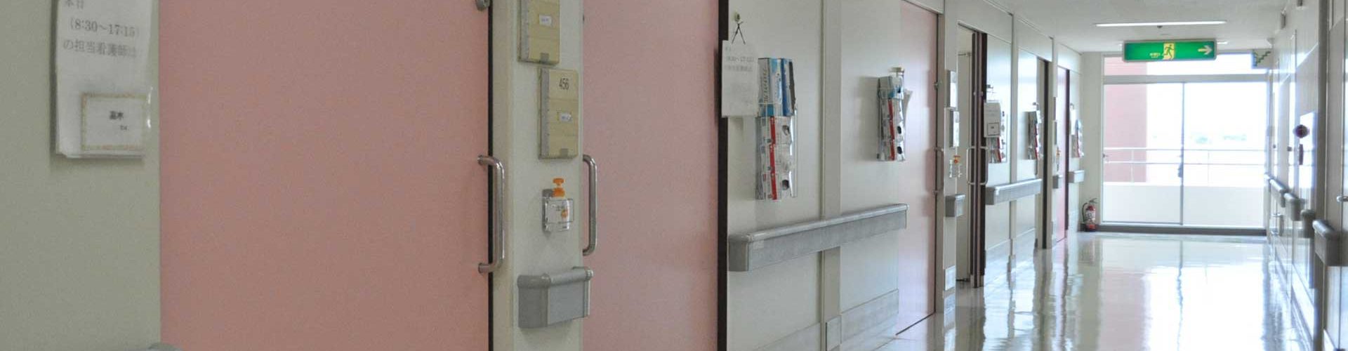 手すりと案内表示を備えた病棟の廊下