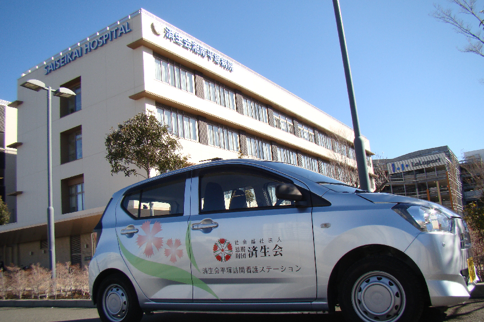病院名表示のある建物と済生会平塚訪問看護ステーションの車両