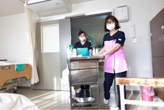公式採用ページに掲載される、病室でケアの準備をする看護スタッフ