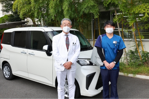 公式訪問診療ページに掲載される、医師とスタッフが訪問車の前に立つ様子