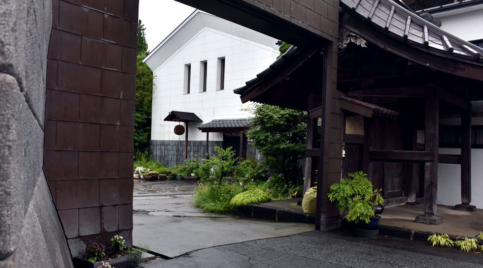 公式の酒蔵紹介ページで、歴史ある建物と白い蔵、庭を写す写真