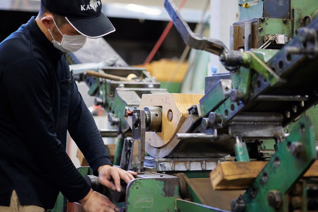 木材部材を機械で加工する作業者