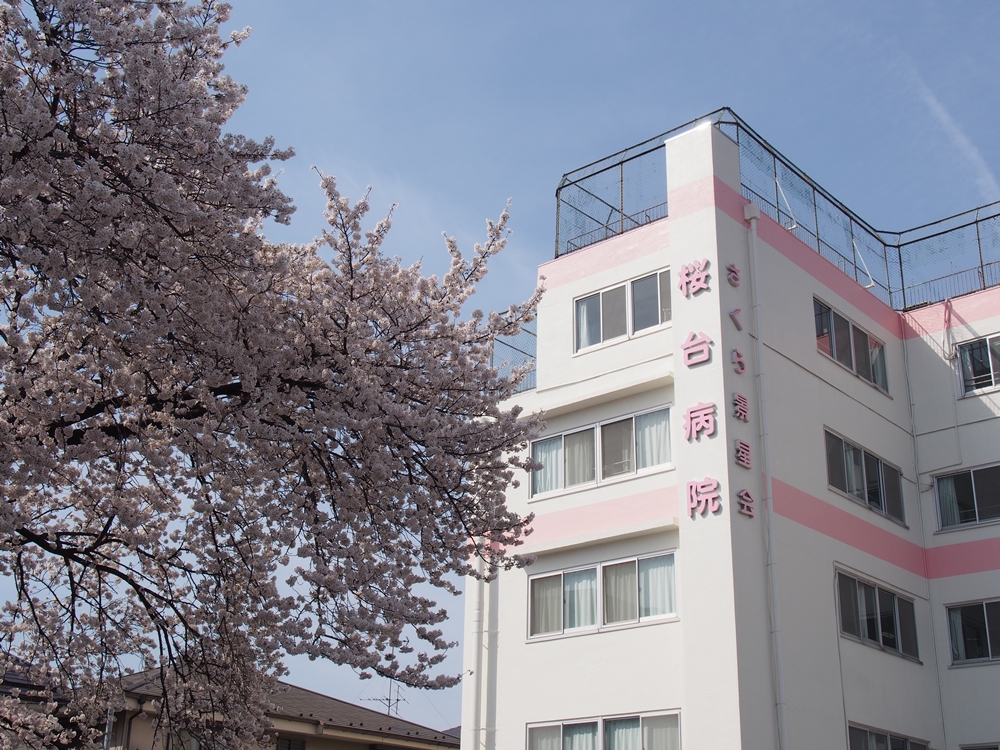桜の木と桜台病院の建物外観