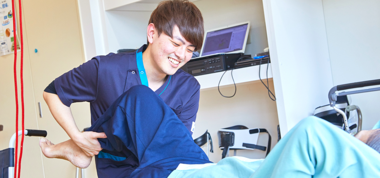 公式トップのスライダーに掲載された、病棟で移動動作を支えるスタッフ