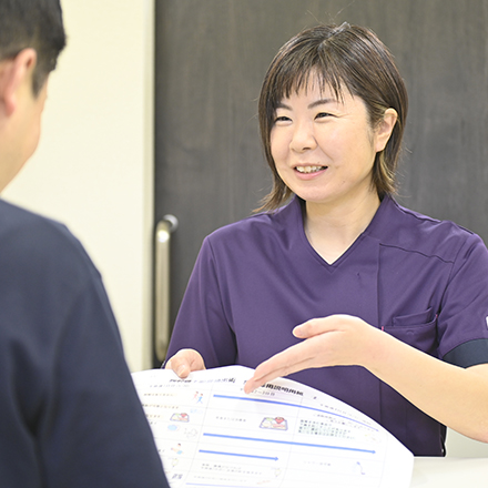 書類を示して説明するスタッフ
