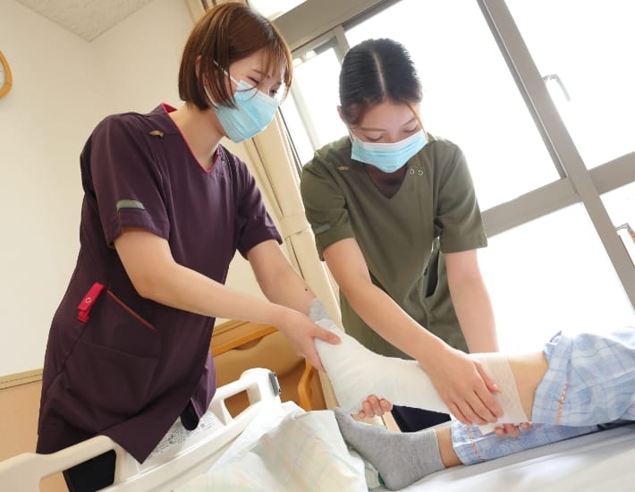 患者の足をケアする看護スタッフ