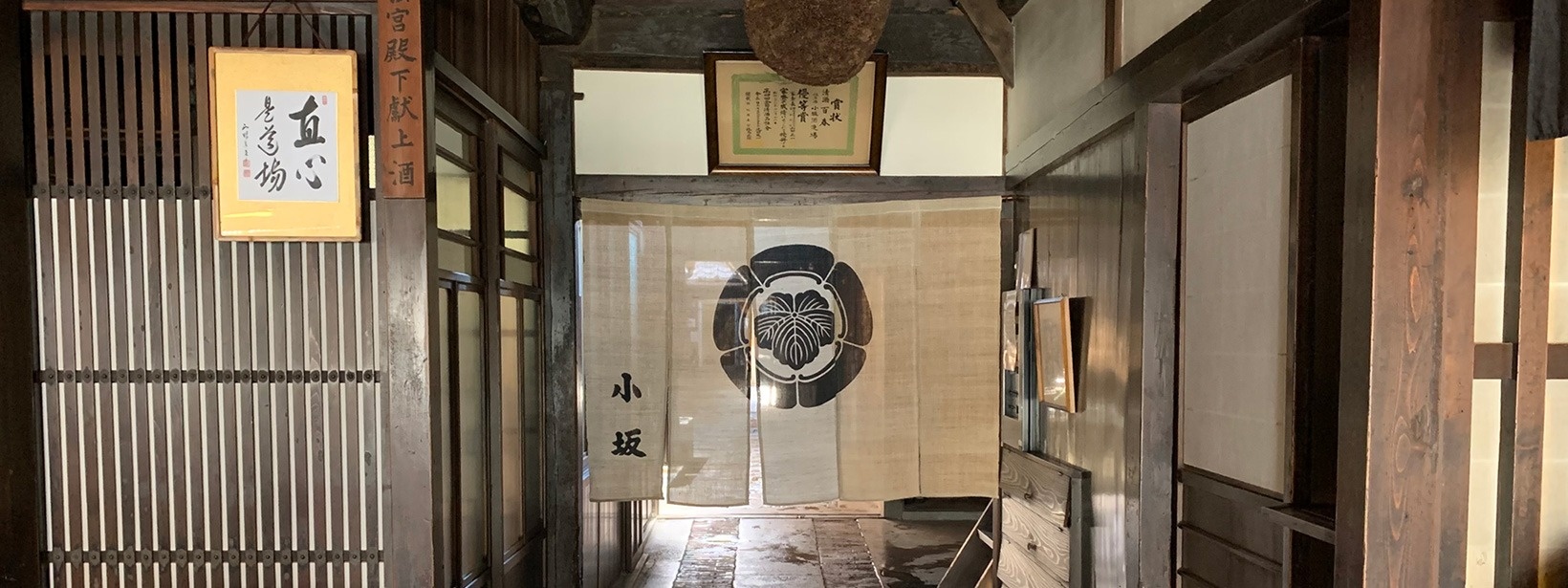 公式トップに掲載された格子戸と暖簾のある酒蔵の入口