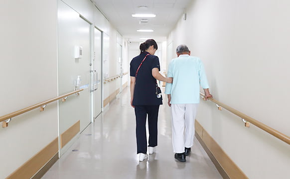 看護職と患者が病棟の廊下を歩く様子