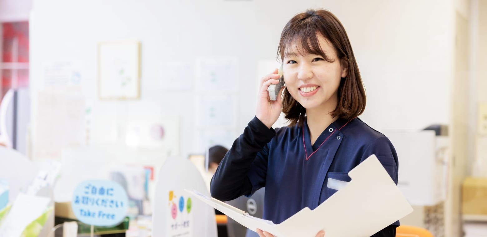 院内で電話と書類を用いて対応するスタッフ