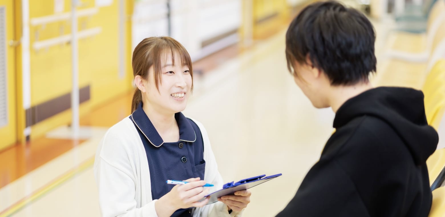 院内で患者に説明・相談対応するスタッフ