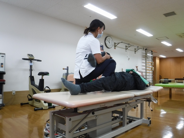 スタッフが利用者に個別リハビリテーションを行う様子