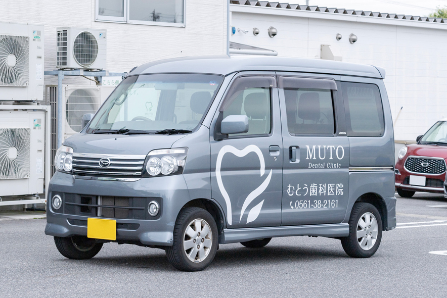 むとう歯科医院の名称と電話番号を表示した訪問診療車