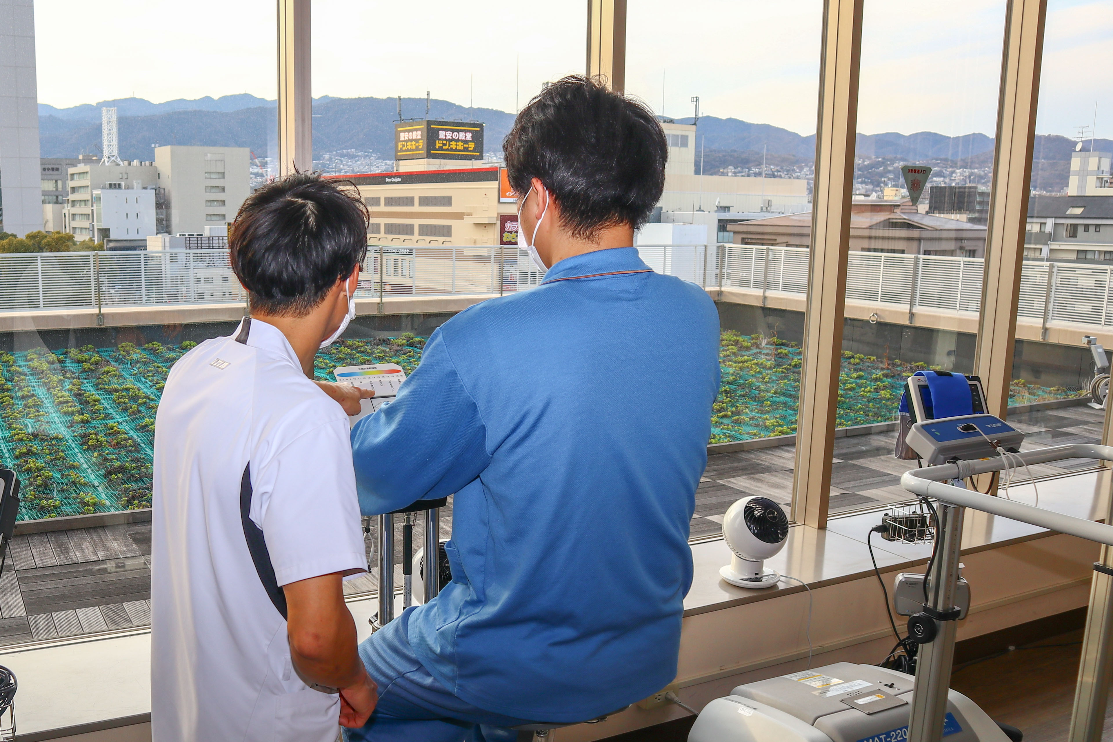 リハビリテーション機器を前に話す職員と利用者
