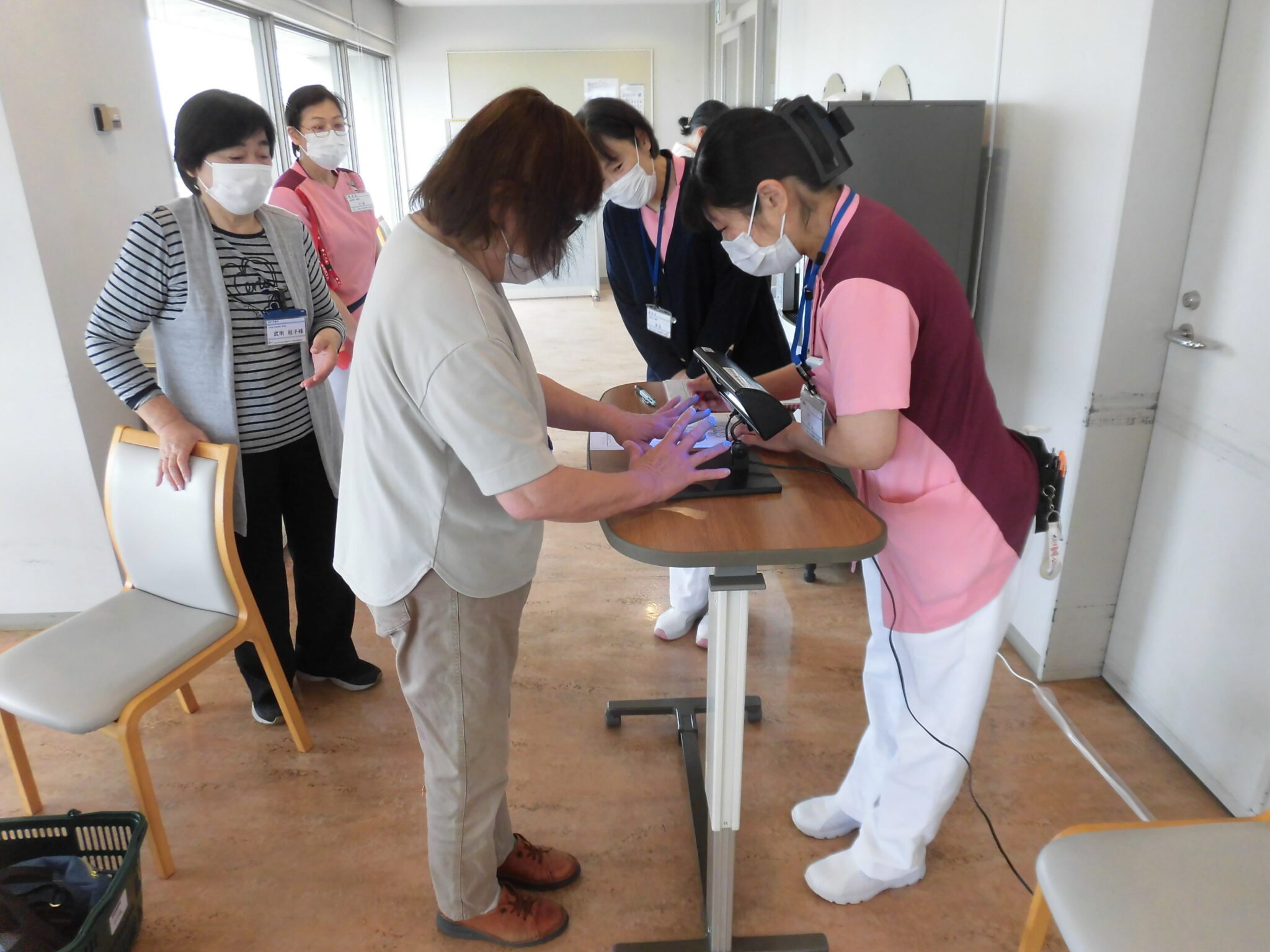 地域の参加者に看護職員が手洗いチェックを案内する様子