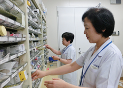 公式部門紹介に掲載される薬剤部スタッフと薬品棚