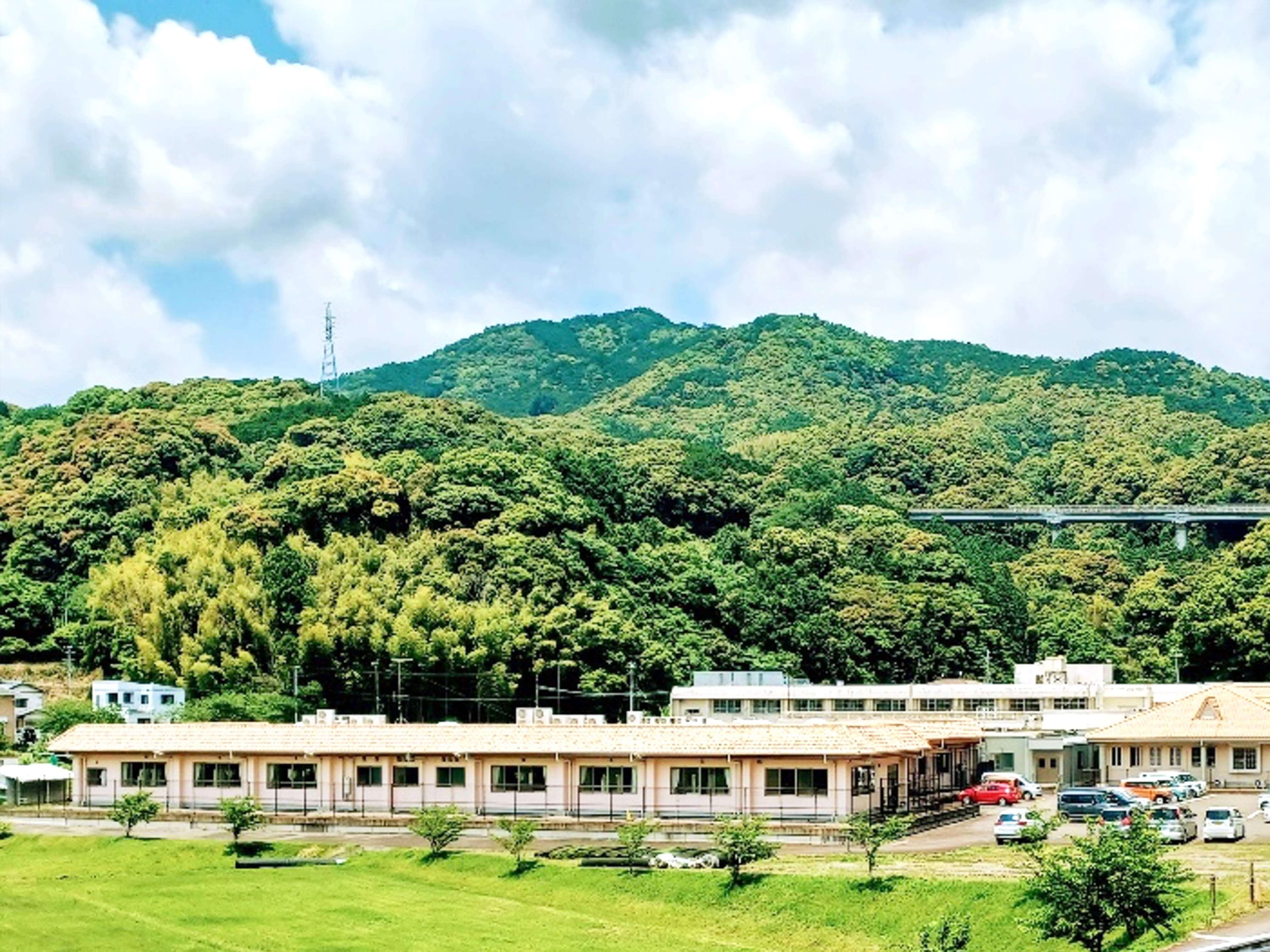 緑の山を背景にした岩﨑病院の建物