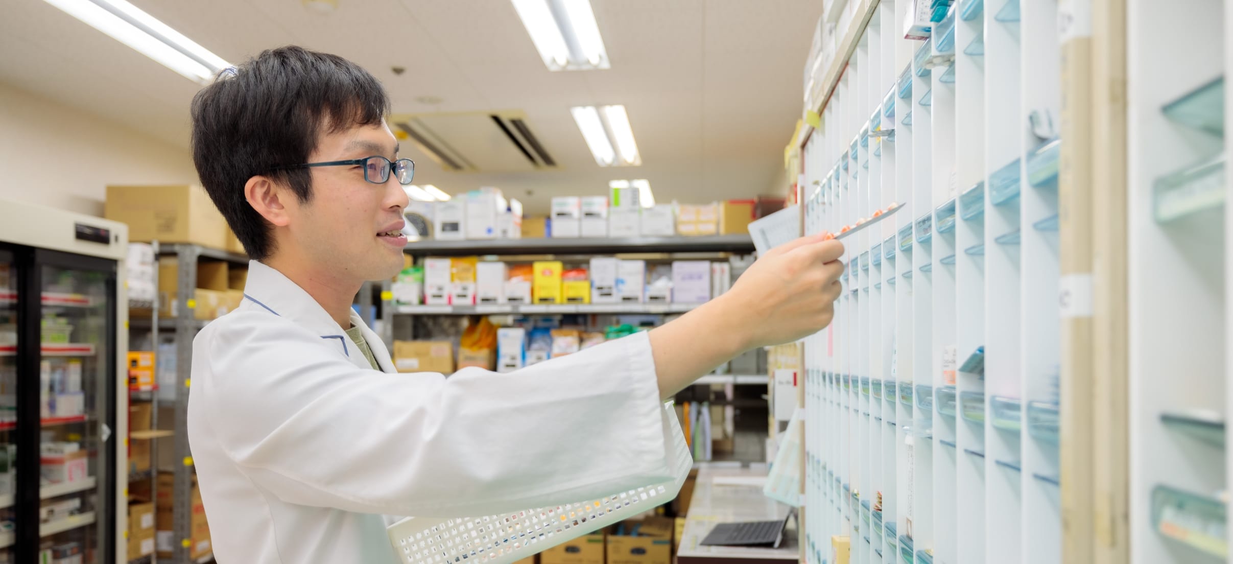 薬剤棚を確認する薬剤師