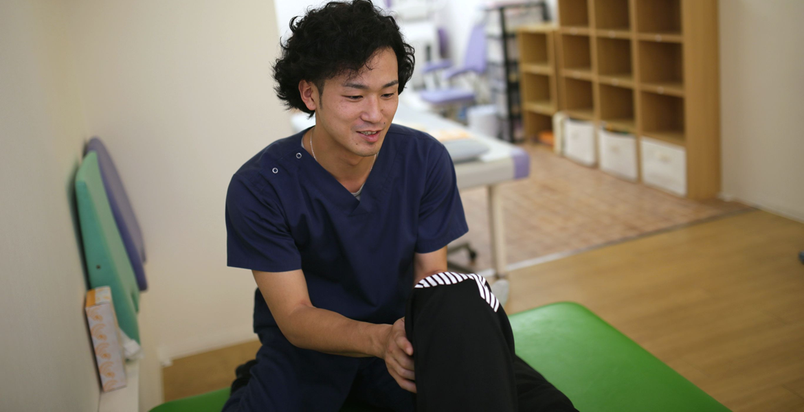 療法士が利用者の膝の動きを支える様子
