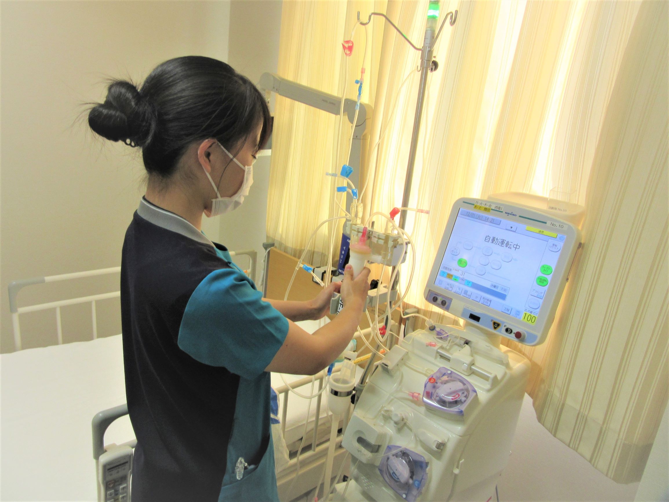 公式透析センター紹介に掲載された、透析機器を扱うスタッフ