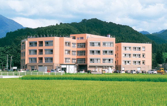公式ごあいさつに掲載された、里山と田園に囲まれた病院外観。
