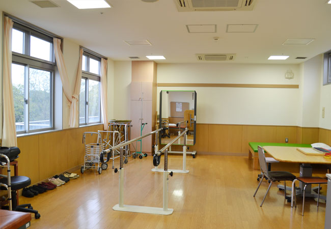 公式リハビリテーション室紹介に掲載される、歩行訓練用の平行棒を備えた室内