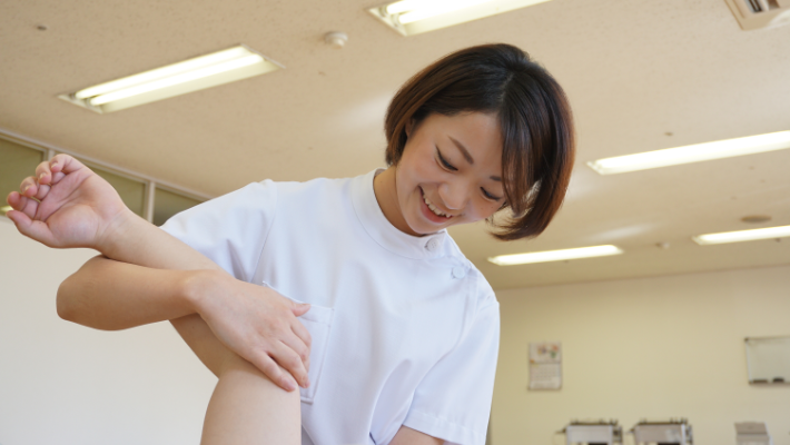 療法士が利用者の膝を支えるリハビリテーション